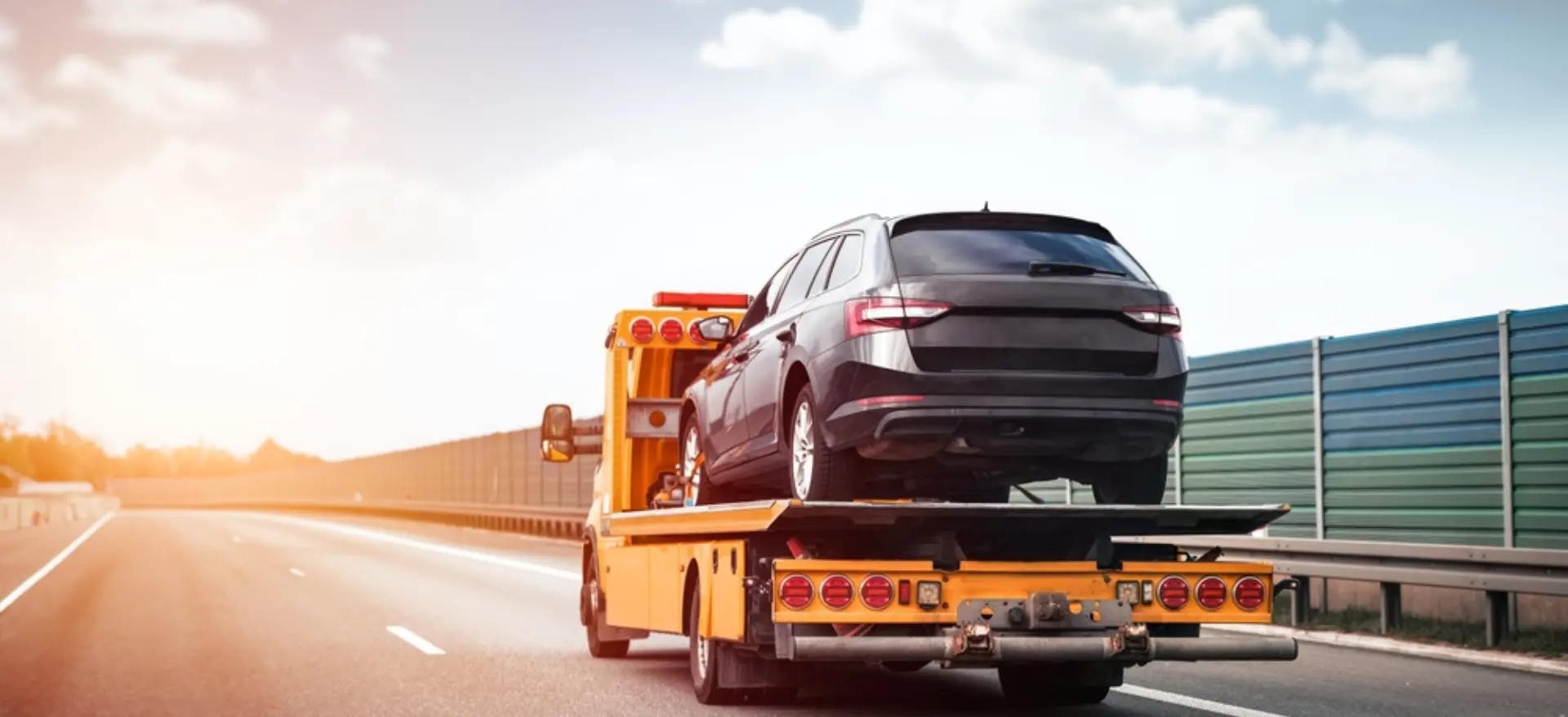 سطحة هيدروليك تنقل سيارة على الطريق